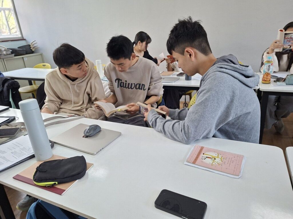在小說閱讀課程中，學生各自帶著一個角色走進故事：有人負責提問，有人整理情節，有人推敲人物的心思，有人把故事連回自己的生活。再透過拼圖式討論（Jigsaw），把每個人讀到的片段帶回小組，拼出一個人讀不到的完整樣貌。一本小說，就這樣從一個人的閱讀，變成一群人用英文一起思考的起點。